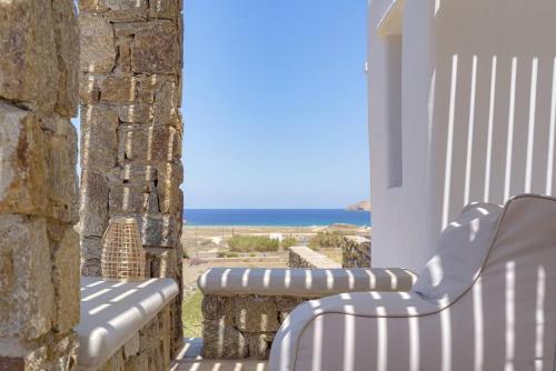 a balcony with a bench and a view of the ocean at Koumi Homes Mykonos in Elia
