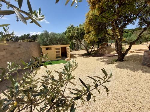 a house in the middle of a field with trees at gite A L' ÉVIDENCE in Mornas