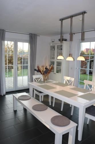 uma sala de jantar com uma mesa branca e bancos em Auszeit am Meer em Zierow