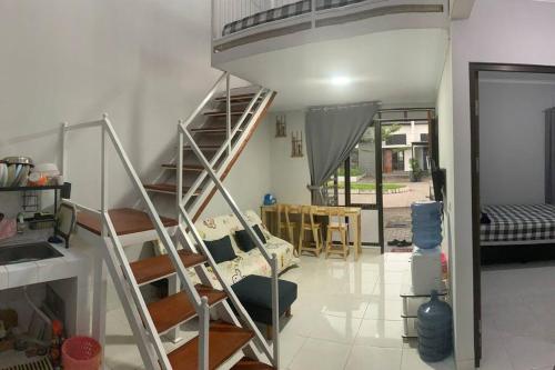 a living room with a spiral staircase in a house at Awana Dream Gateway Pasteur in Bandung