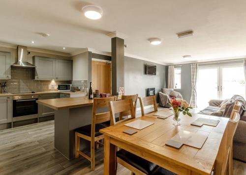 a kitchen and living room with a wooden table and chairs at Sandy Park in Trimdon