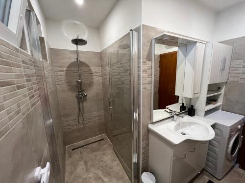 La salle de bains est pourvue d'une douche et d'un lavabo. dans l'établissement Villa Marija, à Crikvenica