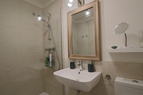 a bathroom with a sink and a shower with a mirror at Apartamento Familiar La Reserva in El Rompido