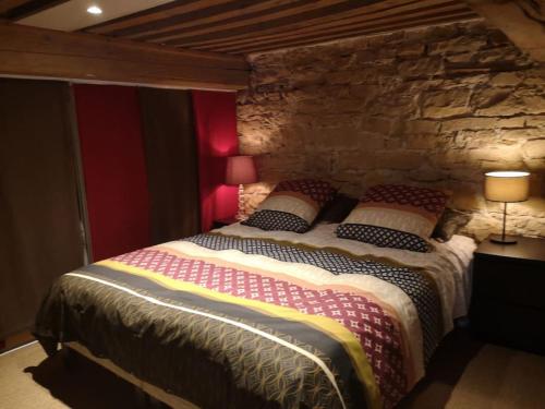 a bedroom with a large bed in a stone wall at bnbgônes - LE LOFT BODIN Croix Rousse - METRO in Lyon