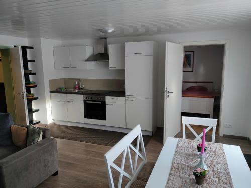 een keuken en een woonkamer met een tafel en stoelen bij Soutterain - Wohnung mit Senkgarten in Weingarten (Karlsruhe)