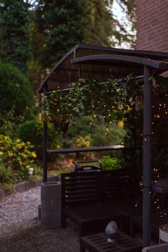 a wooden bench under a gazebo with christmas lights at Boutique Hotel Rosengarten Hamburg in Hamburg