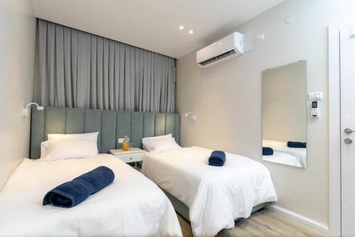 twee bedden in een hotelkamer met blauwe handdoeken erop bij L.T.D luxury apartments 4 bedroom panoramic view in Tiberias