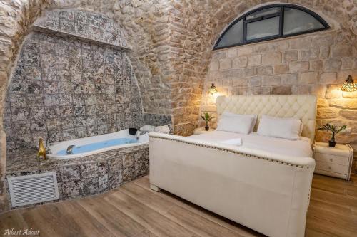 - une chambre avec un lit et une baignoire dans l'établissement Heart Mansion Rashbi compound, à Safed
