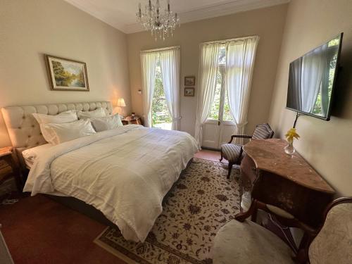 a bedroom with a large bed and a television at Rowan Brae Historic Guesthouse in Blackheath