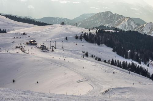 a group of people skiing down a snow covered slope at Presolana Home in Castione della Presolana