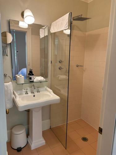 W łazience znajduje się umywalka i prysznic. w obiekcie Rowan Brae Historic Guesthouse w mieście Blackheath