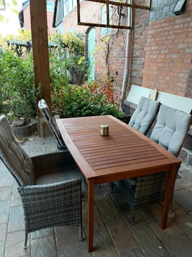 een houten tafel en stoelen op een patio bij MR Ferienwohnung - Einzelzimmer Lina in Schellerten