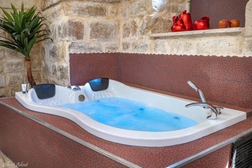 Elle comprend une grande baignoire avec de l'eau bleue. dans l'établissement The Antiquity Heart Mansion, à Safed