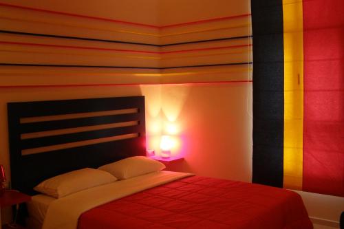 a bedroom with a bed with a red blanket at Room in a neoclassical house - ladybug in Kastoria