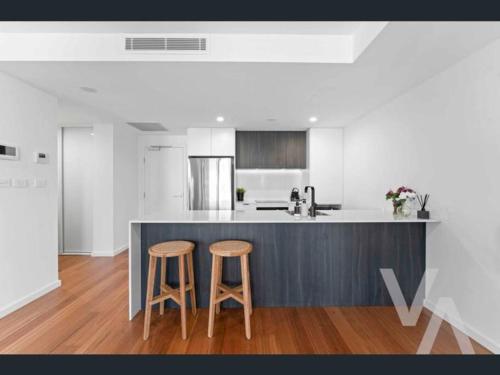 a kitchen with a counter and two stools at 3 Bedroom Sub Penthouse Apartment in the heart of Newcastle in Wickham