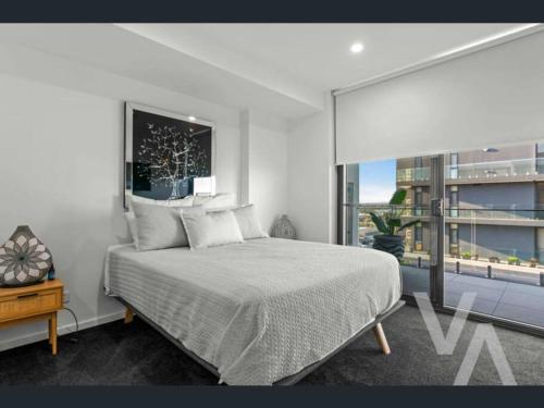 a bedroom with a large bed and a large window at 3 Bedroom Sub Penthouse Apartment in the heart of Newcastle in Wickham