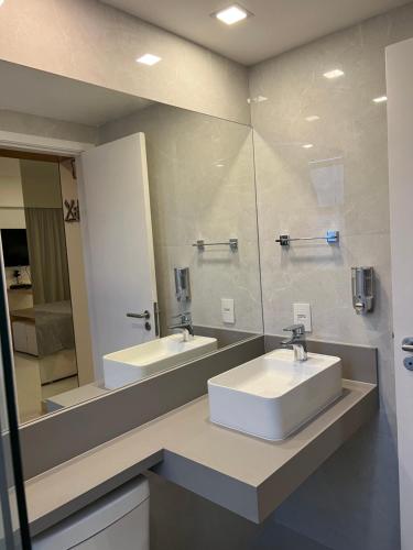 a bathroom with two sinks and a large mirror at Flat na praia in Rio de Janeiro