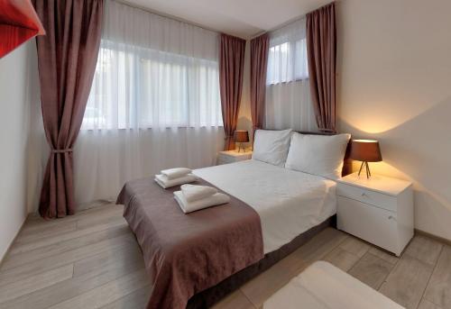 een slaapkamer met een bed met twee handdoeken erop bij Forest Lodges in Konjic