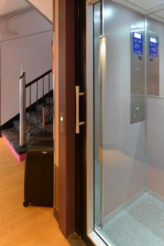 a sliding glass door with a suitcase next to a staircase at Urban Style hotel de l'Europe in Rouen