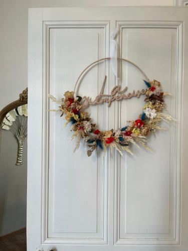 a wreath on the door of a white door at Gite L'Instant Champenois in Bréviandes