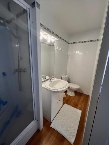 une salle de bain blanche avec un lavabo et une douche dans l'établissement La Mongie magnifique Appart 7 pers vue pistes, piscine, wifi, salle de sport, à La Mongie