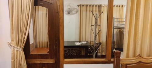 Armario de madera con espejo en una habitación en Whispering Pinewoods, en Pīrmed