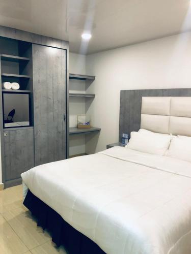a bedroom with a large white bed and a sliding door at Hotel San Antonio Guarne in Guarne