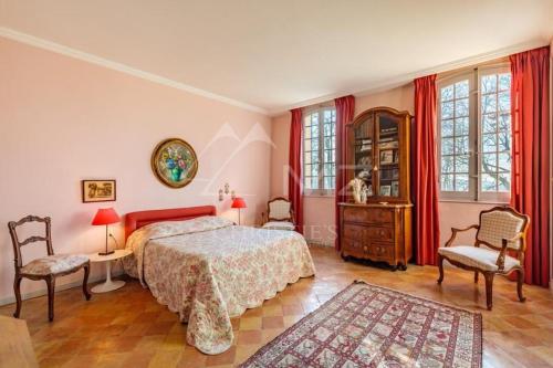 een slaapkamer met een bed, 2 stoelen en een dressoir bij Suite le Quervalat dans magnifique bastide 18eme in Aix-en-Provence
