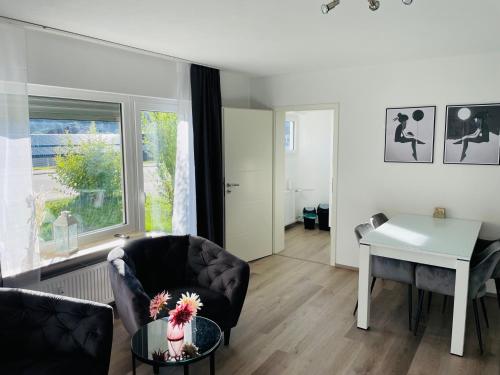 a living room with a desk and a chair and a table at Zollernalb-Apartment MG in Albstadt