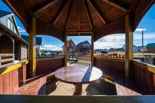 a wooden porch with a wooden table on a deck at Village Villa North Wind in Žabljak