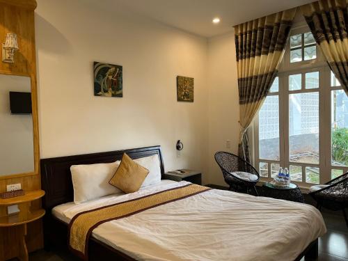 ein Schlafzimmer mit einem Bett und einem großen Fenster in der Unterkunft Khách sạn Hương Mê in Buon Ma Thuot