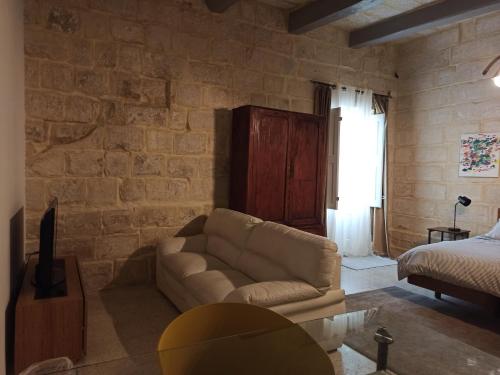 a living room with a couch and a bed at Beautiful Studio apartment in Qormi Malta in Qormi