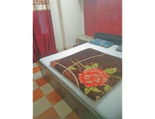 a bedroom with a bed with a flower on it at Hotel Landmark Lodge, Jammu in Jammu