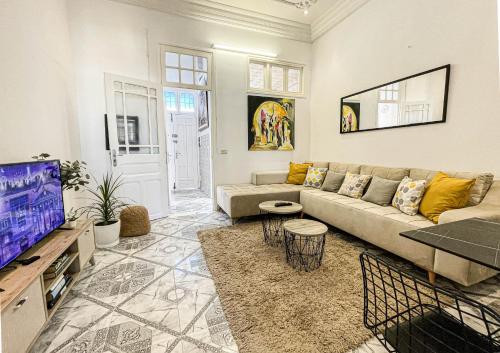 - un salon avec un canapé et une télévision dans l'établissement COSY Apartment in La Marsa Corniche - Beach, à La Marsa