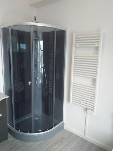 a glass shower in a bathroom with a window at STUDIO NOYANT VILLAGES in Noyant