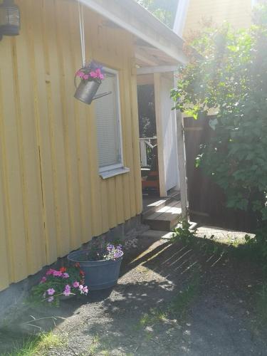 una casa con una maceta de flores a un lado en Mummon saunamökki en Helsinki