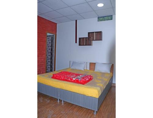 a bedroom with a bed with a red blanket on it at Hotel Jungle View Resort, Bhogpur in Kandogal