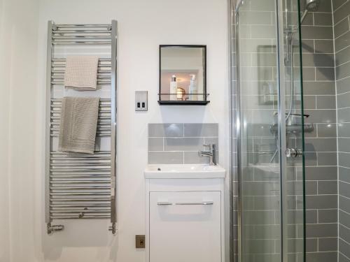 a bathroom with a sink and a glass shower at 8 Oaks Court in Leiston