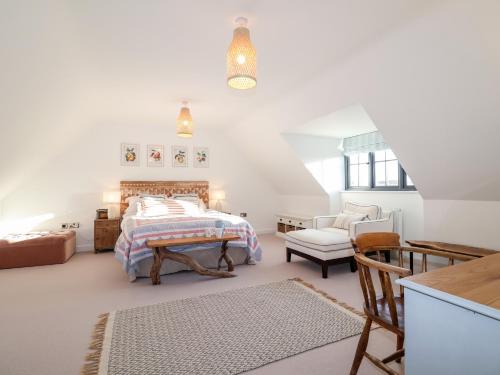 a bedroom with a bed and a chair at 8 Oaks Court in Leiston