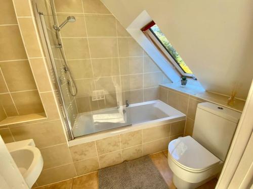 a bathroom with a toilet and a shower and a sink at Charming 3/4 bedroom semi-detached cottage. in Carberry