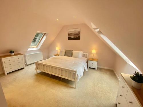 Charming 3/4 bedroom semi-detached cottage. في Carberry: غرفة نوم مع سرير مع مواقف ليلتين ومصباحين