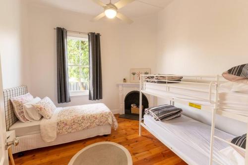 a bedroom with two bunk beds and a fireplace at Newly renovated, Kennedy Cottage - close to CBD in Bendigo