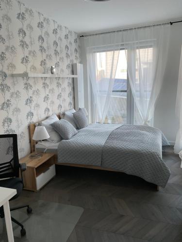 a bedroom with a large bed and a window at Apartament „Dwie Wieże” in Katowice