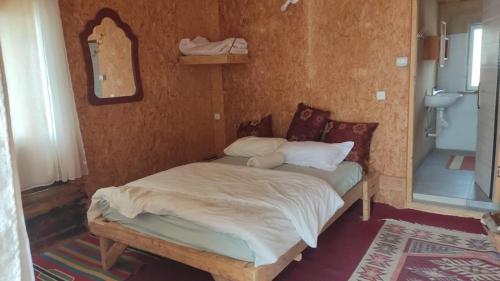 a small bed in a room with a mirror at Zman Midbar Eco Spirit Lodge for Peace in Arad