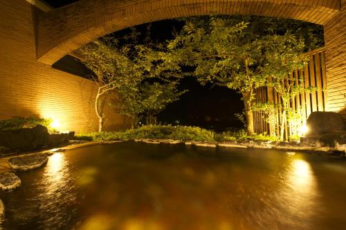 a pool of water under a bridge at night at Hotel Village Izukogen in Ito