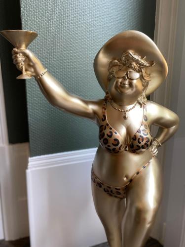a statue of a woman in a bikini holding a cup at Le Clos maison 3 chambres avec extérieur et parking Epernay centre in Épernay