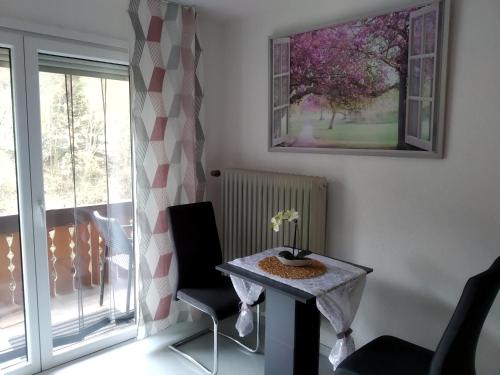 een tafel en stoelen in een kamer met een raam bij Ferienwohnung Sonnenblick in Oberharmersbach