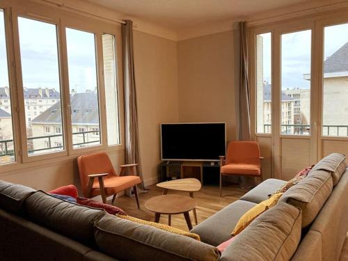 a living room with a couch and a flat screen tv at Appart 90m2 lumineux, centre, vue église penchée in Caen