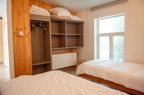 a bedroom with two beds and a window at Poezelhoekvallei Loft in Zonnebeke