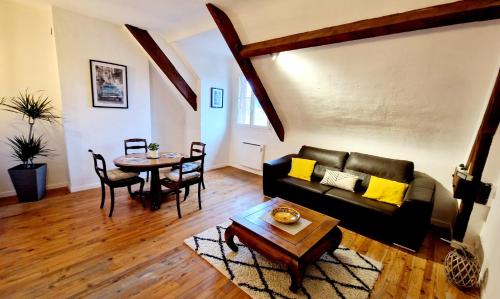ein Wohnzimmer mit einem Sofa und einem Tisch in der Unterkunft Appart plein centre, vue cathédrale, fibre in Lisieux